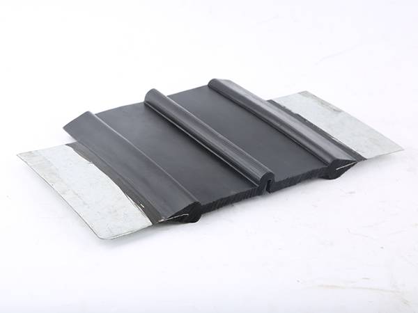 A piece of steel edge waterstop with center bulb on gray background.