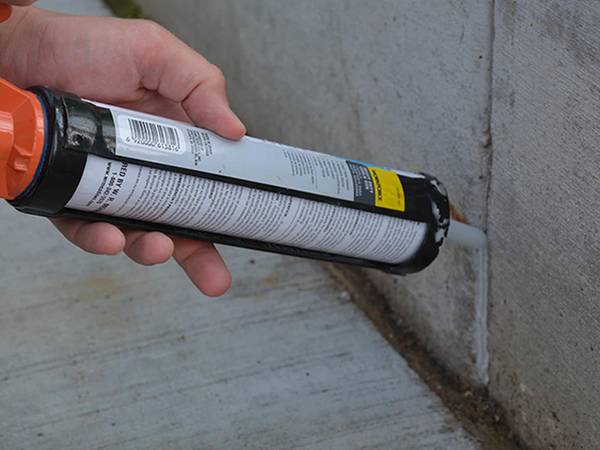 A people is fixing the wall seam with white single component polyurethane water-swelling sealant.