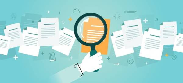 A man is holding a magnifying glass for information research.